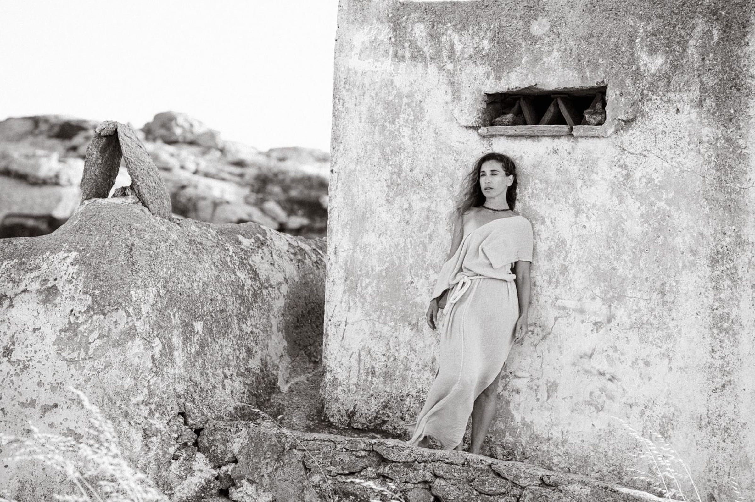 Leaning on a whitewashed stone wall in summer light